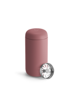 A pink Fellow Carter Move Mug with metal infuser lid sits beside it.