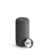 Matte black Fellow Carter Move Mug with round metal lid, partially open on a white background.