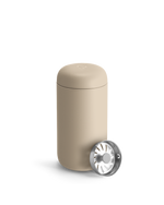 Beige Fellow Carter Move Mug with removable metal infuser lid placed beside it.