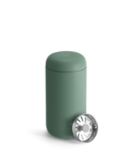 Matte green Fellow Carter Move Mug with lid and metal strainer in front.