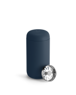 The Fellow Carter Move Mug is a dark blue tumbler with a metallic lid on its cylindrical body.