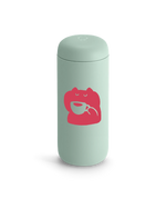 Light green Fellow Carter Move Mug with a pink frog holding a teacup on the front.