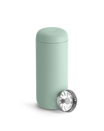 Fellow Carter Move Mug in light green with stainless steel strainer on a white background.